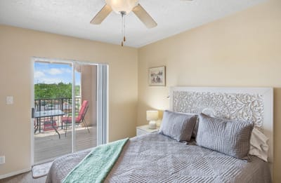 Cozy bedroom with balcony access in a senior living facility