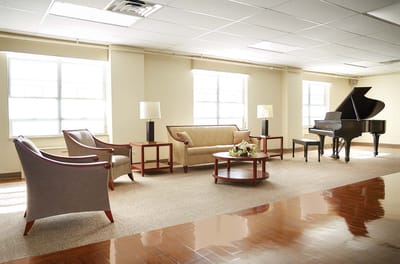 Bright lounge area with seating and a piano