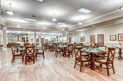 Bright dining room with set tables and flowers