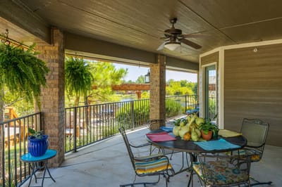 Covered patio with outdoor seating and greenery
