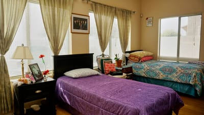 A cozy resident room with two beds and natural light