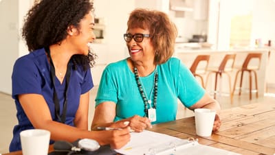 Staff member interacting with a resident in a bright interior