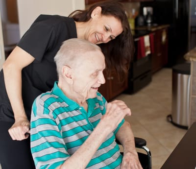 Staff assisting a resident in a bright room