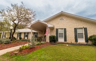 Exterior view of the assisted living facility with landscaped gardens