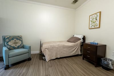 Interior view of a resident room with a bed and chair