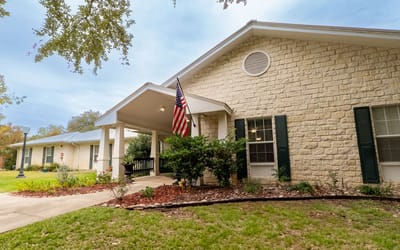 Building exterior of Gemstone Senior Living with American flag