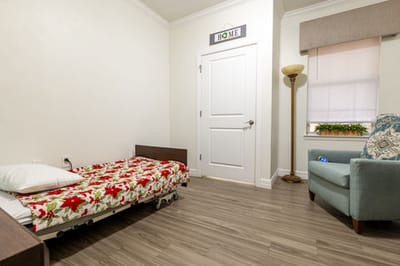 Private resident room with bed and armchair