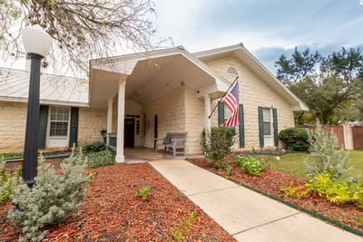 Front entrance of a senior living facility with garden