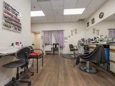 Salon area with styling chairs and nail polish rack