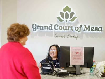 Staff member assisting a resident at the reception desk