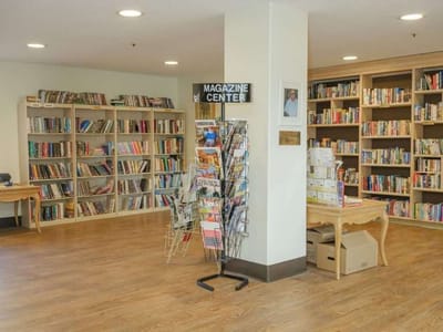 Interior view of a library with bookshelves and magazine center