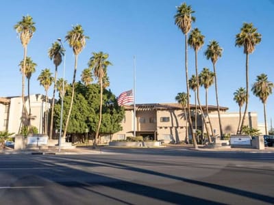 Exterior view of Grand Court of Mesa with palm trees