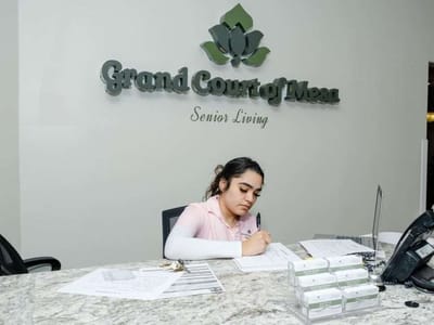 Staff member at reception desk writing notes