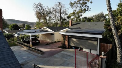 Aerial view of a house with solar panels and carport