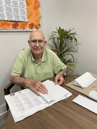 An elderly resident working on art in a common area