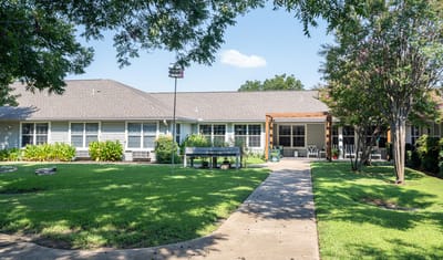 Exterior view of assisted living facility with landscaped lawn