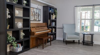 Interior of a common area with a piano and bookshelves