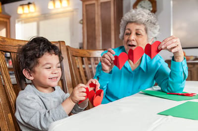Senior resident engaging in arts and crafts with a child