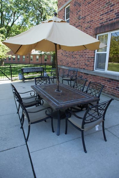 Citadel at Saint Benedict, Nursing Home in Niles, IL — Outdoor dining set under a large umbrella