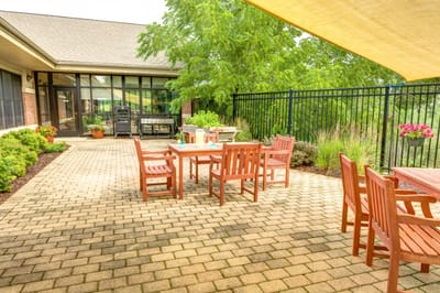 Outdoor patio with wooden tables and chairs at The Auberge at Oak Village