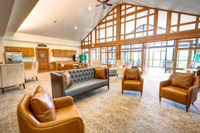 Cozy living room with tufted sofa and leather chairs at The Auberge at Oak Village