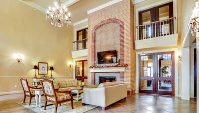 Campanile on Justice Park, independent living in Houston, TX — Elegant common room with seating and fireplace