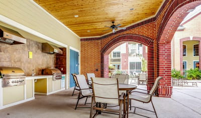 Campanile on Justice Park, independent living in Houston, TX — Outdoor lounge area with seating and barbecue grills