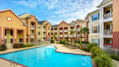 Campanile on Justice Park, independent living in Houston, TX — Swimming pool surrounded by residential buildings and greenery