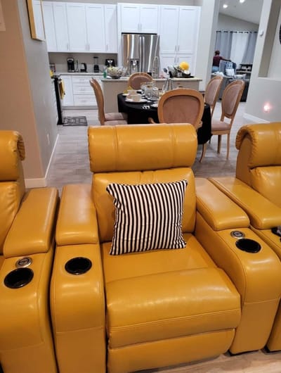 Interior seating area with yellow recliners and dining table