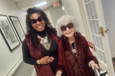 Staff member with resident in a cozy indoor hallway