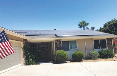 Facility building exterior with solar panels and an American flag