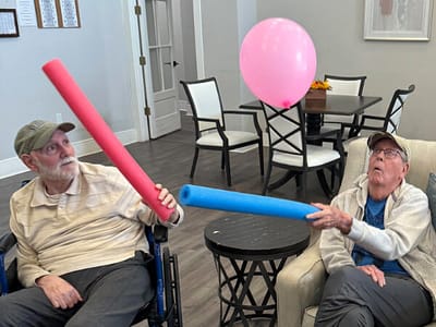 Residents enjoying a playful activity with pool noodles