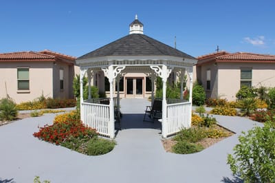Gazebo surrounded by colorful flowers in a senior living facility
