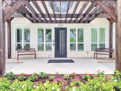Entrance area of a senior living facility with benches and flowers