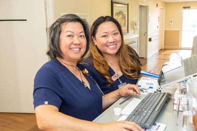 Two staff members smiling at a reception area