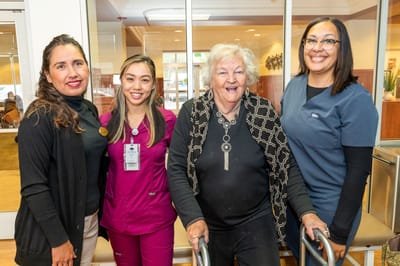 Staff and resident smiling together in a common area