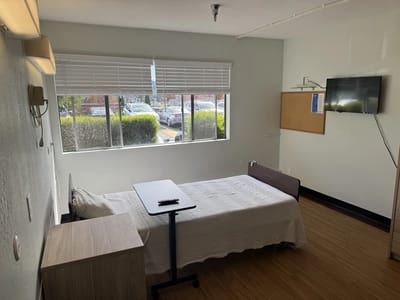 Interior view of a resident room with a bed and TV