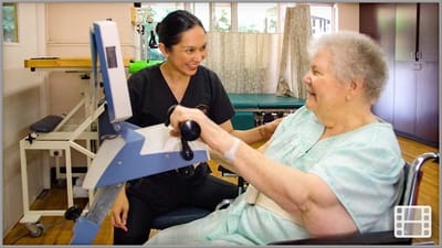 Healthcare staff assisting a resident with therapy equipment