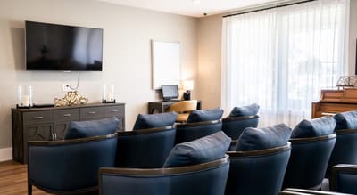 Common area with seating and piano in a bright room