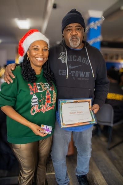 Two people celebrating with award and festive clothing.