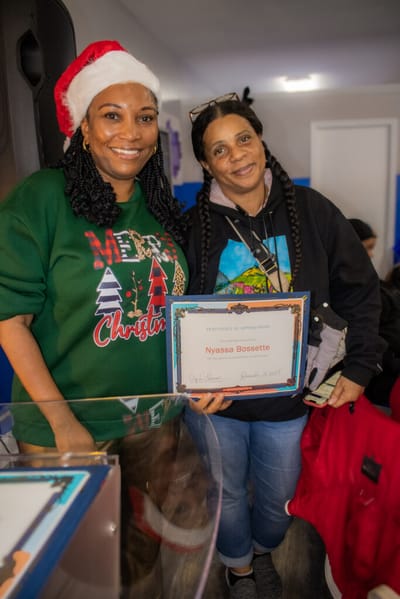 Two women celebrating with a certificate.