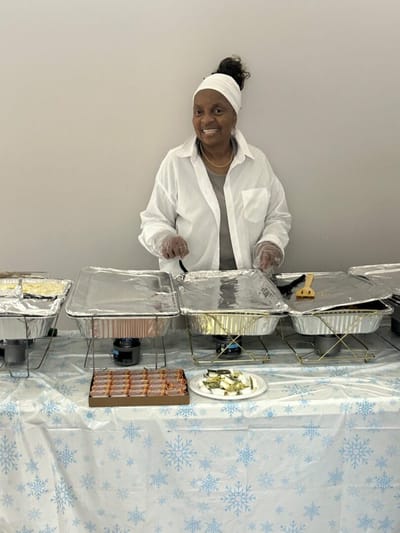 Resident serving food during a dining event.