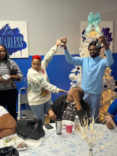 Residents celebrating with activities around a decorated tree.