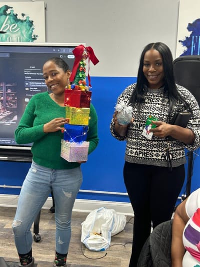Two women holding festive decorations.