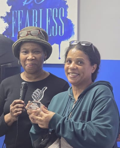 Two women celebrating with an award.