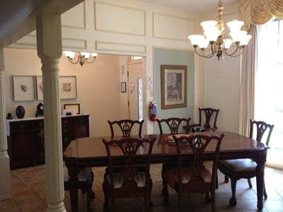Elegant dining room with large wooden table and chairs.