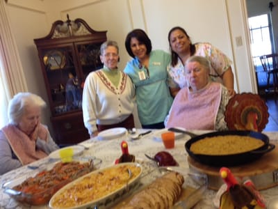 Residents enjoying a meal with staff members.