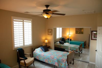 Cozy resident room with two beds and warm lighting.