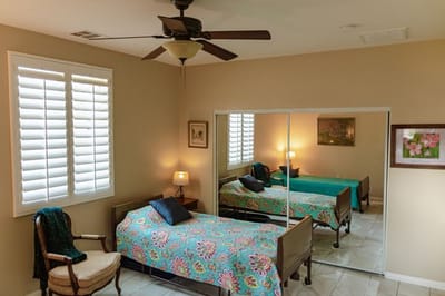 A private resident room with a floral bedspread.