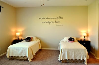 Decorated resident room with two beds and a quote